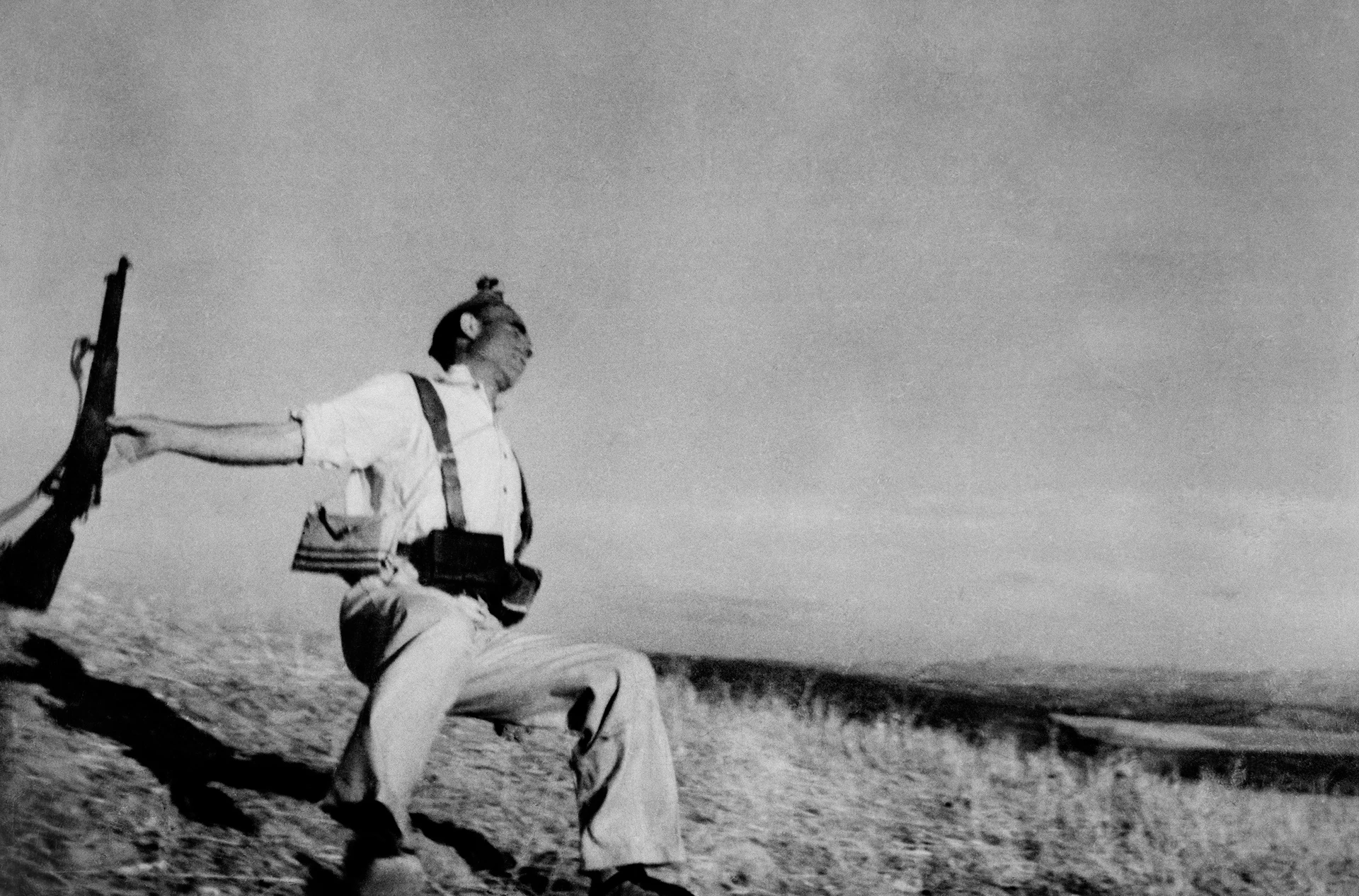 Imagen en blanco y negro, soldado es disparado y cae al suelo